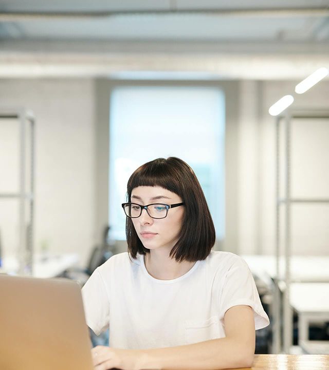 studying-woman-working-on-laptop-in-office-with-white-background